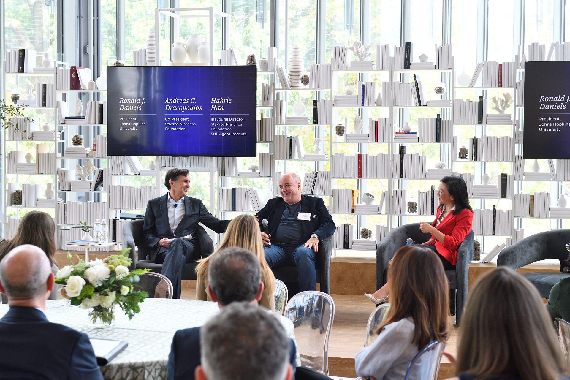 Τρία άτομα σε ένα panel discussion σε εκδήλωση του SNF Agora Institute.